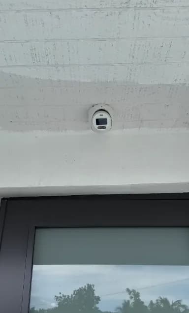 Dome camera mounted on a white ceiling above a door